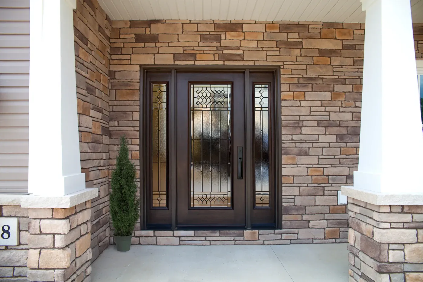 A Brown door with sidelights in a home with white walls