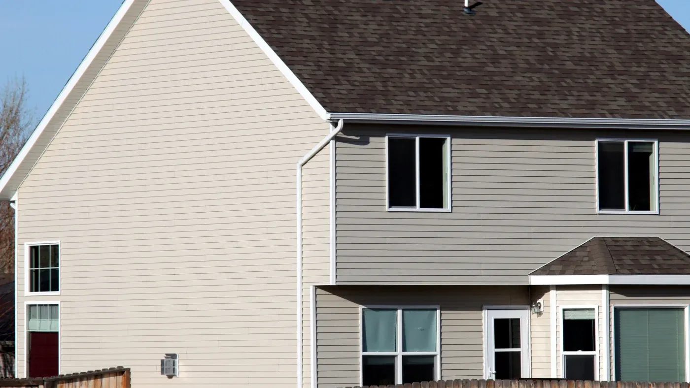 A home with beige siding and a brown roof