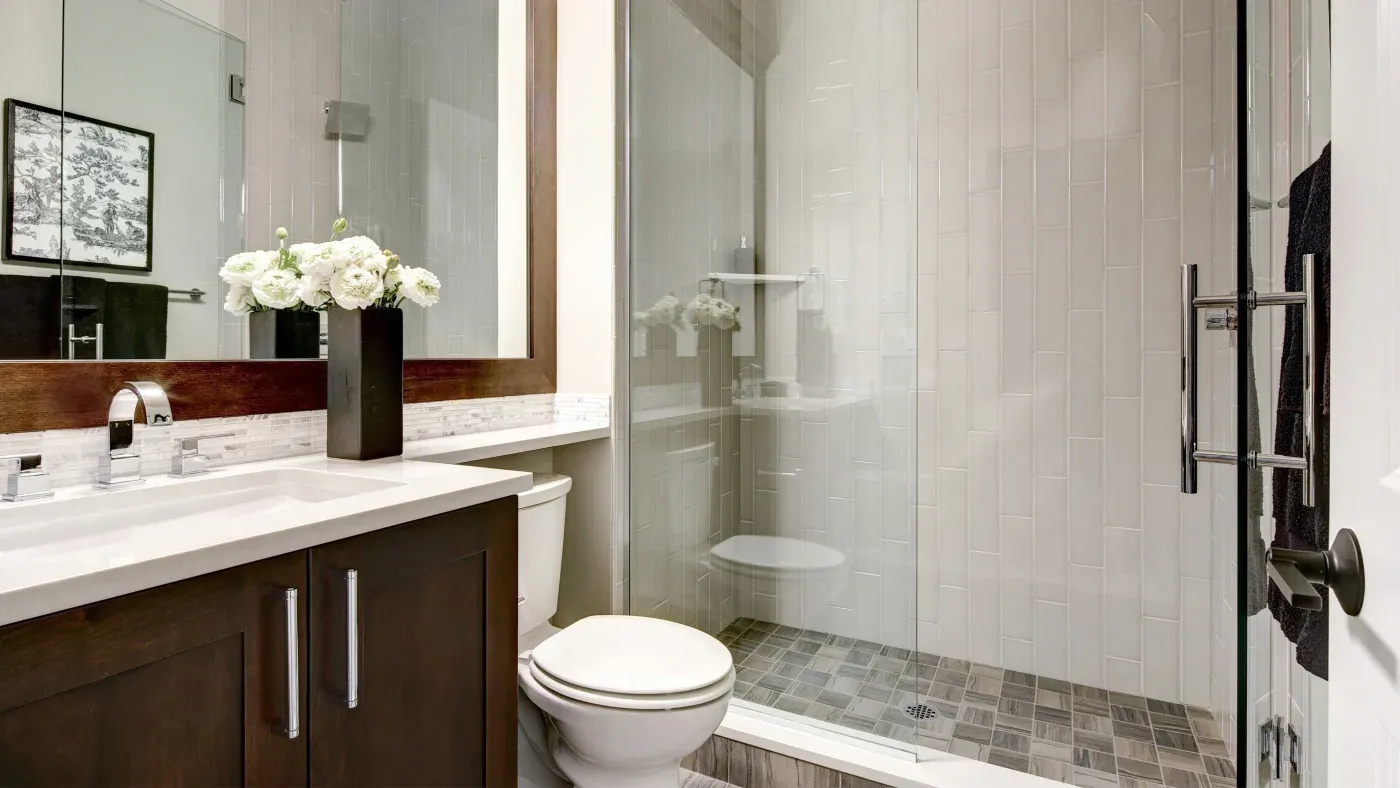A bathroom with a walk-in shower with white surrounds
