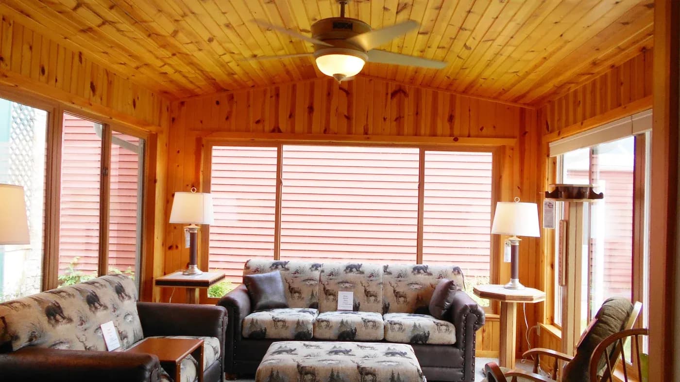 A sunroom with wood walls and windows