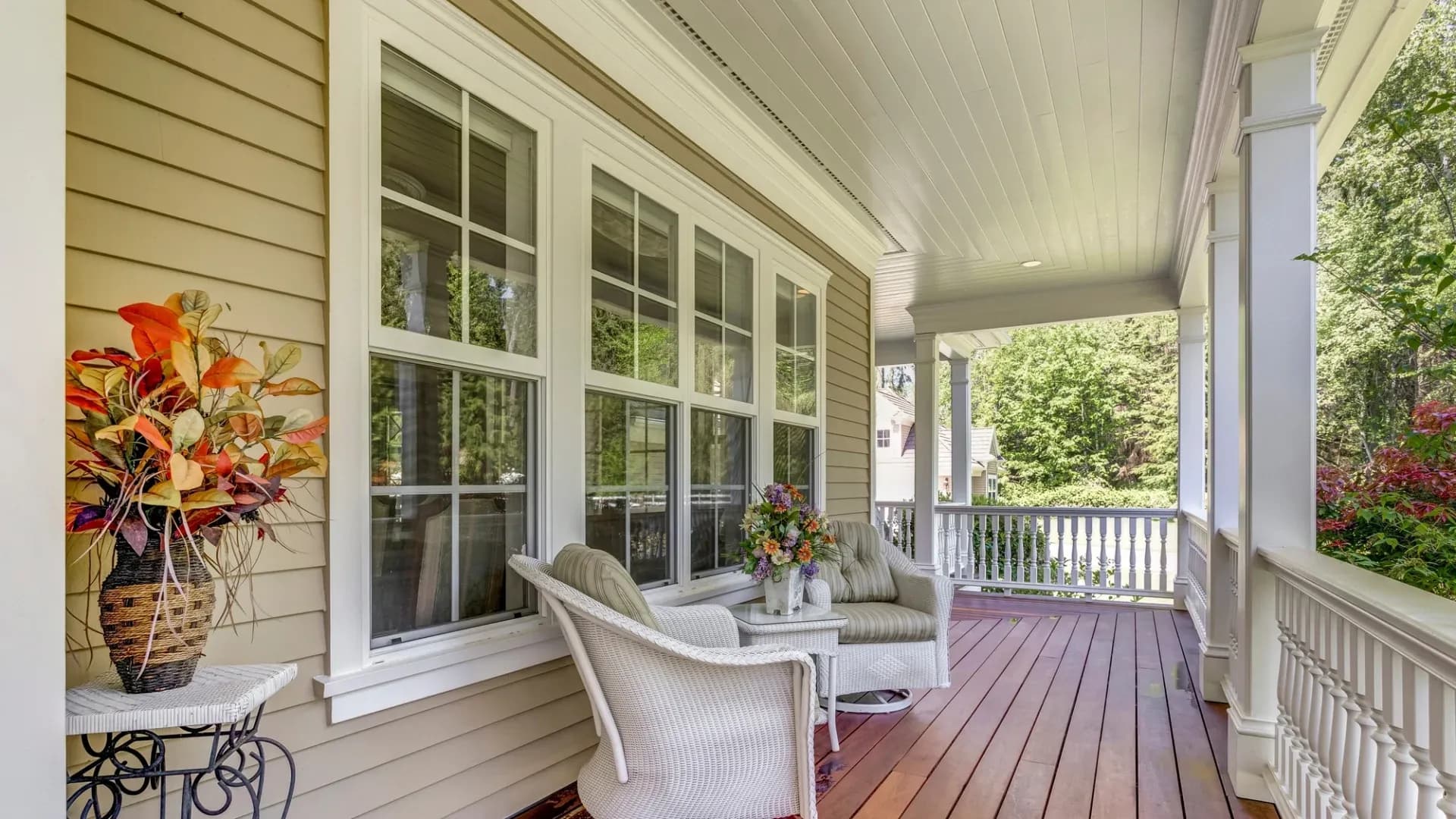 White-framed windows on the front of the home with deck chairs in front of them