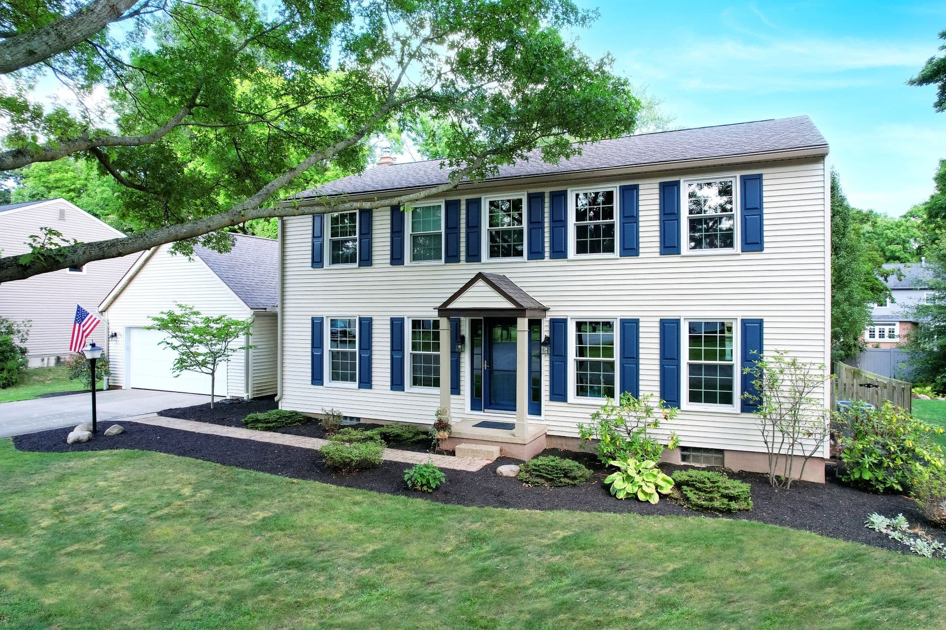 Endure Double-Hung replacement windows on a white house with blue shutters.