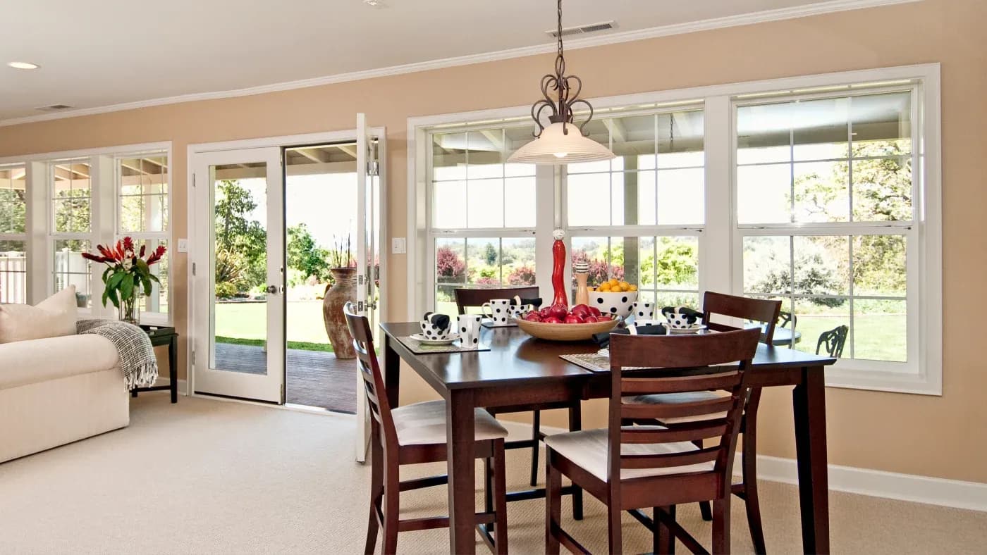 A dining room with large white windows