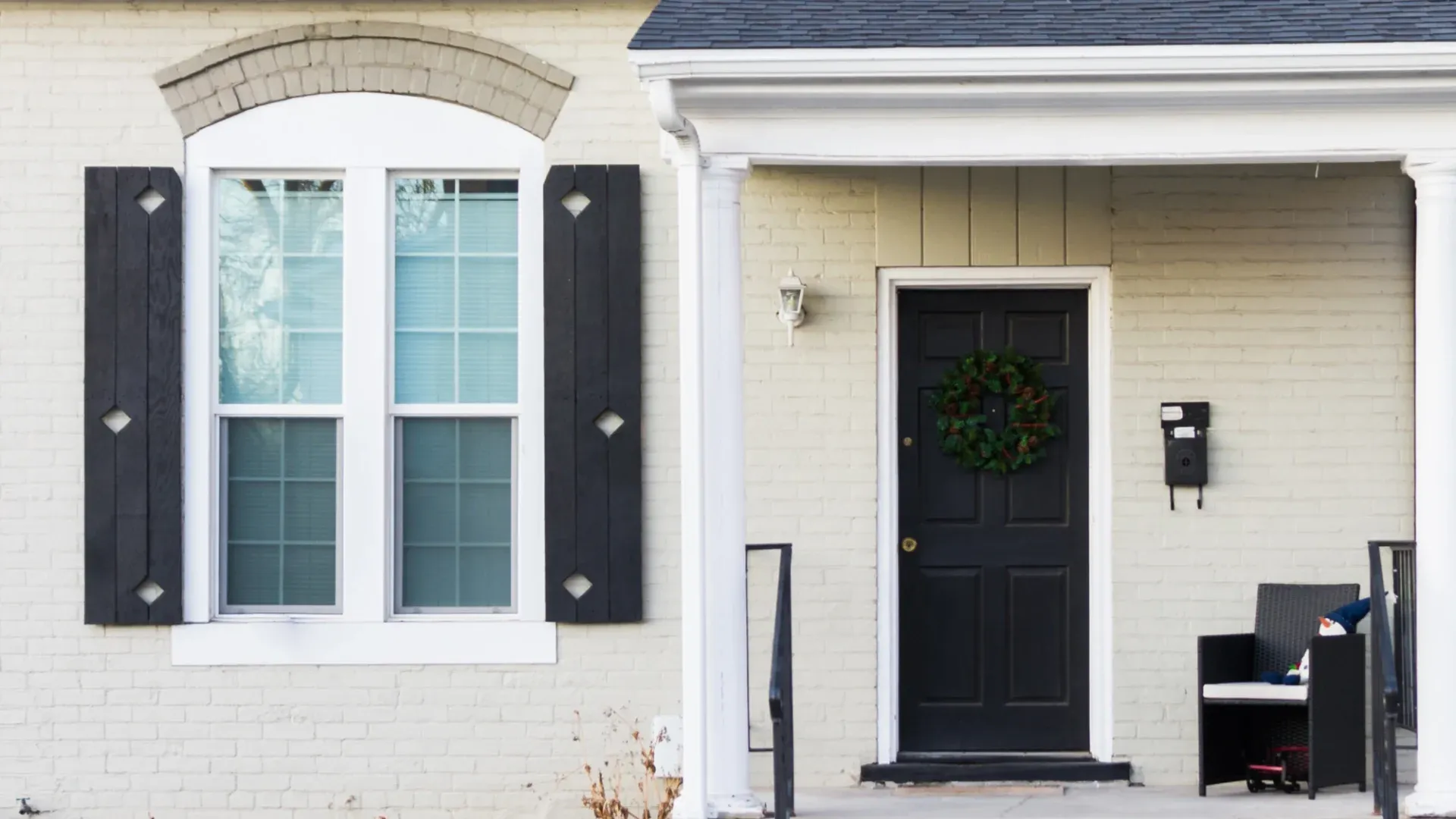 A home with white windows and a black front door