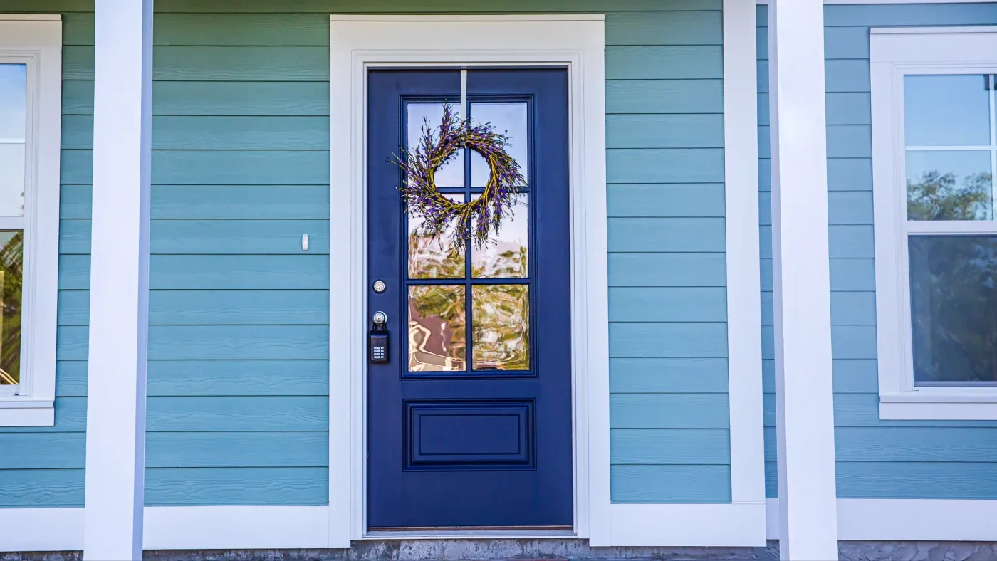 A blue door in a home with blue siding