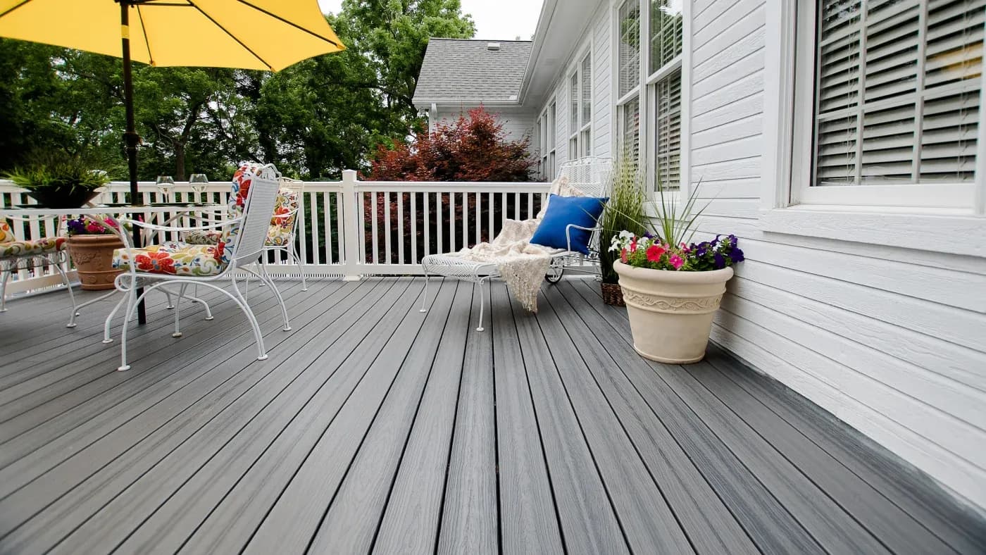 A gray deck with white railings and white furniture
