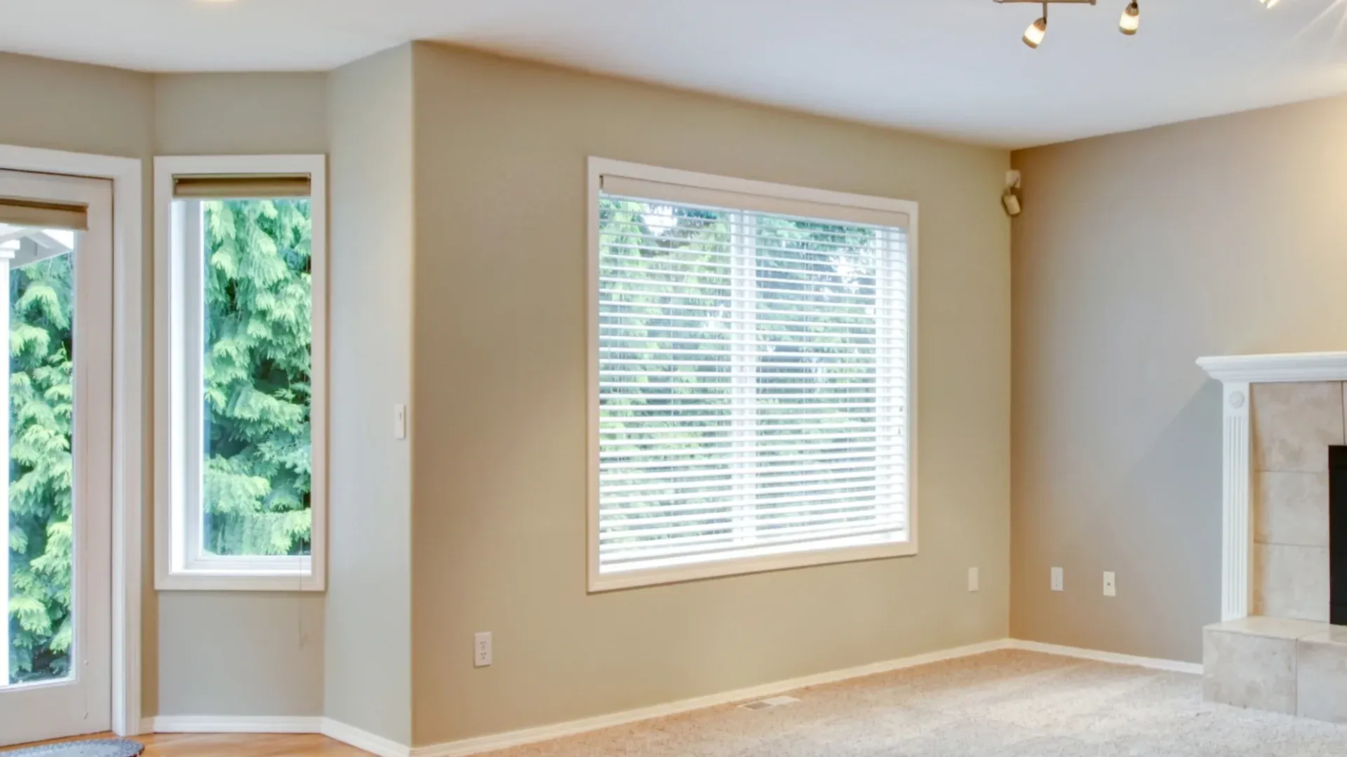 A room with beige walls and a large window