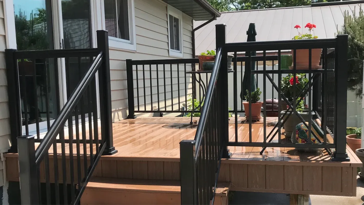 A large brown deck with black railings