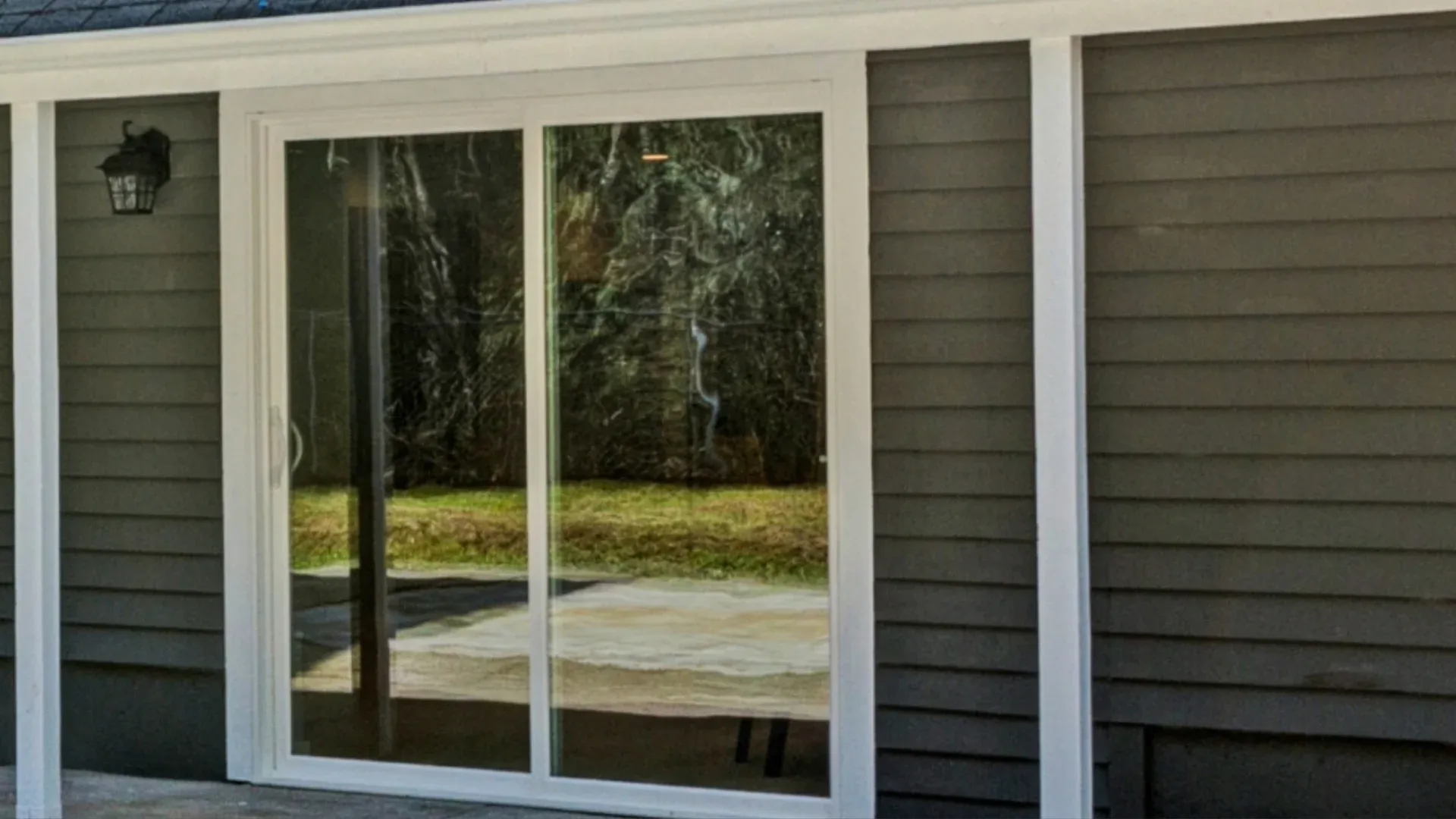 A home with gray siding and sliding patio doors with white trim