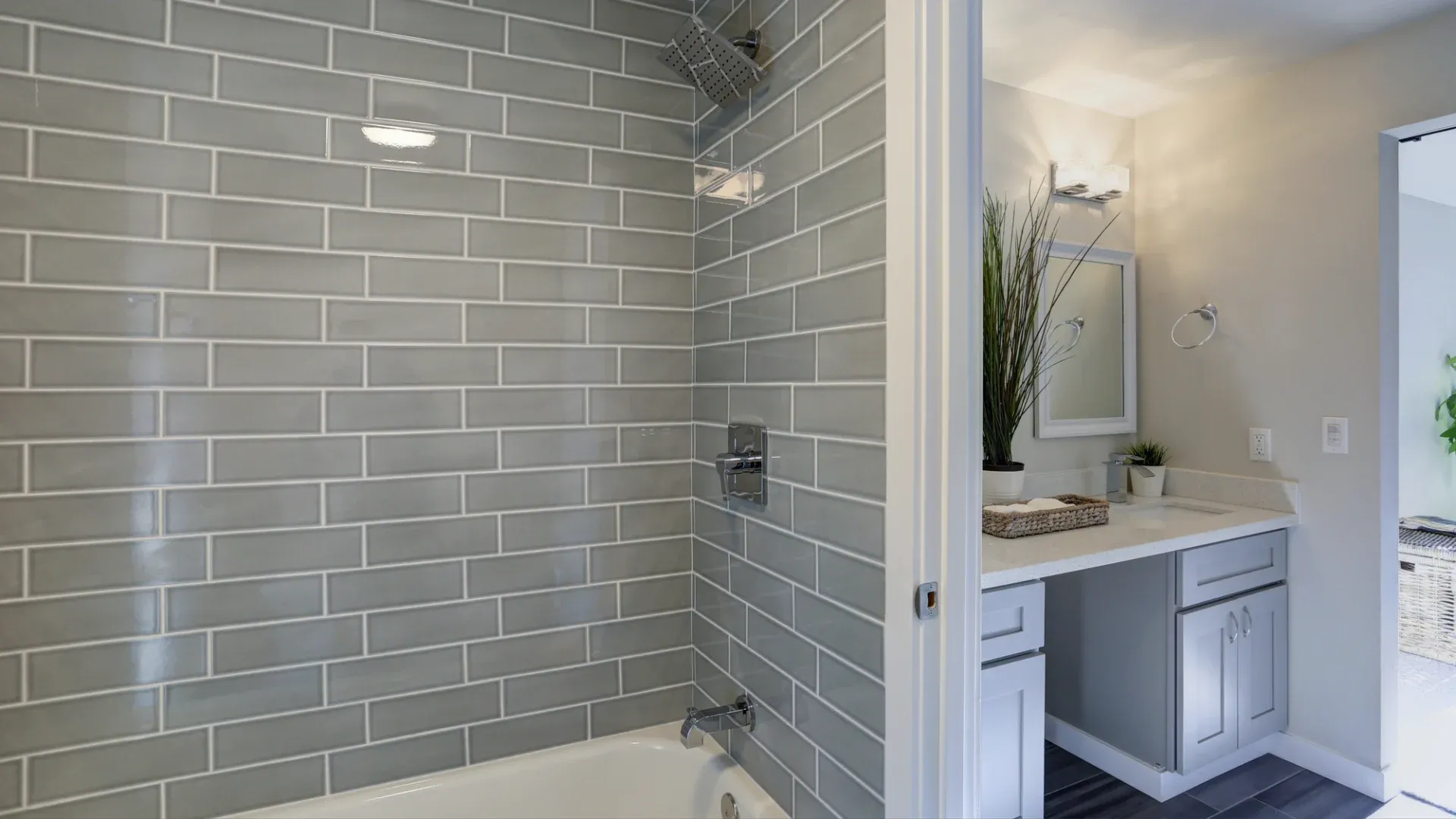 A bathroom with a light blue vanity and a blue shower with a rainfall showerhead
