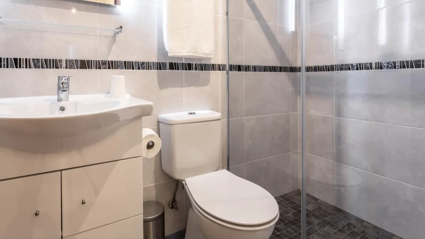A bathroom with a walk-in shower and white walls