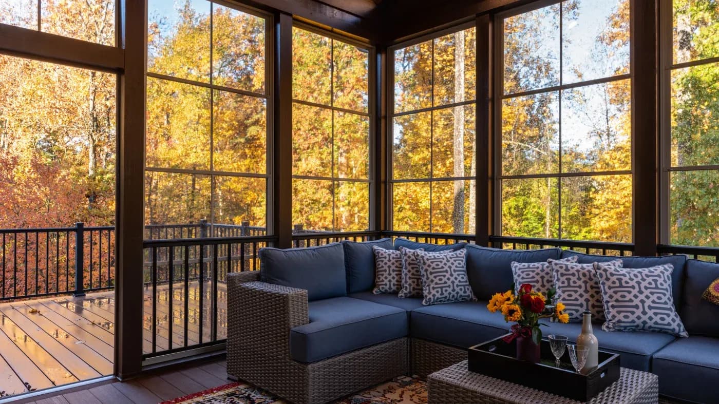 Sunroom with fall trees and a blue couch